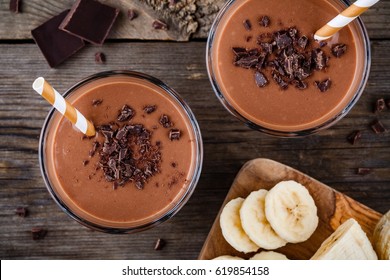 Chocolate smoothie with banana on rustic wooden background