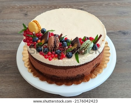 Chocolate sponge cake with dark chocolate mousee, whiskey cream mousse, sour cherries jelly and mascarpone cream frosting. Selective focus.