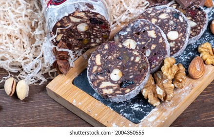 Chocolate Sweet Sausage With Nuts And Dried Fruits Cut On A Board. Close-up.