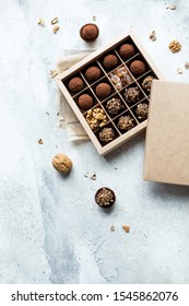 Chocolate Truffle Balls With Cocoa Powder In Blank Craft Paper Box, Sweet Delicious Gift Dessert For Winter Hoildays On Marble Background,  Selective Focus And Copy Space For Text, Top View