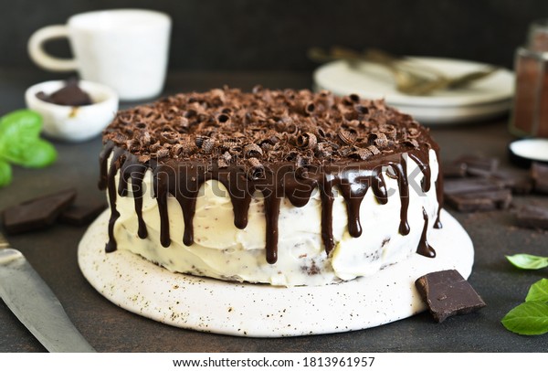 Chocolate truffle cake with cream cheese on a\
dark background.