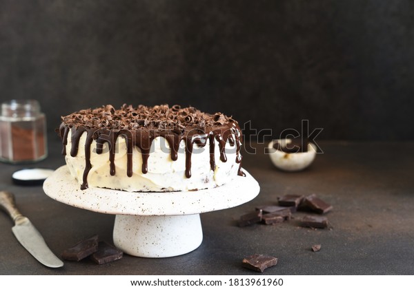 Chocolate truffle cake with cream cheese on a\
dark background.