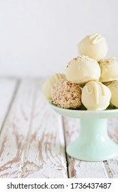 Chocolate truffle candies on white chocolate with nuts. Chocolate sweets on a light background, homemade sweets