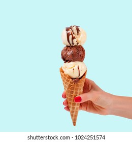 Chocolate And Vanilla Ice Cream Cone On Faded Pastel Color Background. Hand Holding Ice Cream In Wafer Cup.