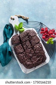 Chocolate Vegan Brownie Pie With Tahini And Fresh Raspberries On A Blue Background