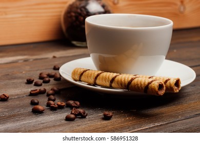 chocolate wafer rolls on a saucer, coffee,..