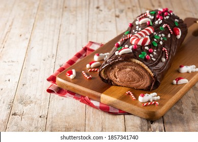 Chocolate yule log christmas cake on wooden table.Copy space