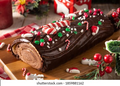 Chocolate yule log christmas cake on wooden table