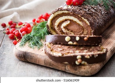 Chocolate yule log christmas cake with red currant on wooden background.closeup
 - Shutterstock ID 516061909