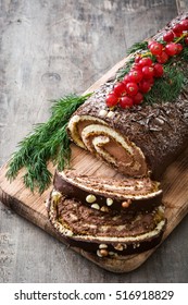 Chocolate yule log christmas cake with red currant on wooden background.copyspace
 - Shutterstock ID 516918829