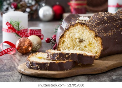 Chocolate yule log christmas cake and christmas ornament on wooden background
