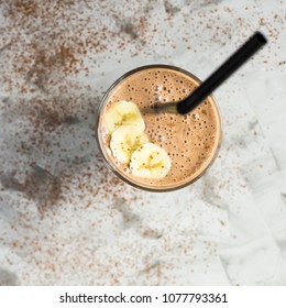 Chocolate-banana smoothies with cocoa in a glass on a gray background. Healthy food concept