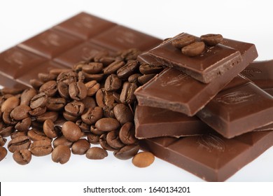Chocolate-Coffee background: Scattered parts of broken bar dark bitter or milky chocolate and many fried coffee beans isolated on white background without shadows