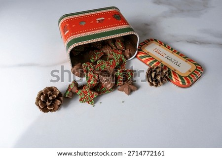 Chocolates in different shapes emerging from a cookie tin.