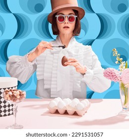Chocolates lover. Stylish woman in cylinder har and sunglasss eating chocolate eater egg. Blue pattern background. Concept of pop art, creativity, food, inspiration and imagination, contemporary photo