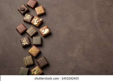 chocolates praline variety on brown background with copyspace