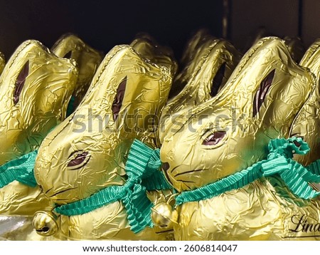 Chocolates in the shape of a cute Easter bunny wrapped in gilded paper are on the market shelf.