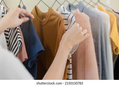 Choice Of Clothes, Nothing To Wear Asian Young Woman, Girl Hand In Choosing Dress, Outfit On Hanger In Wardrobe In Room Closet At Home. Deciding What To Put On Which One.