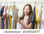 Choice of clothes,Nothing to wear. Attractive asian young woman, girl try on appare, happy choosing dress, outfit on hanger in wardrobe in room closet at home. Deciding blouse what to put on which one