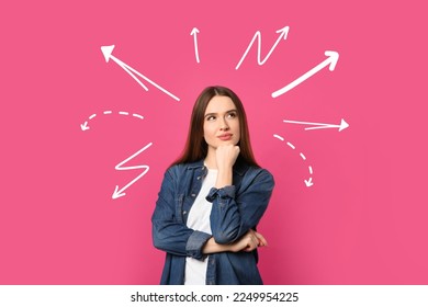 Choice in profession or other areas of life, concept. Making decision, thoughtful young woman surrounded by drawn arrows on pink background - Shutterstock ID 2249954225