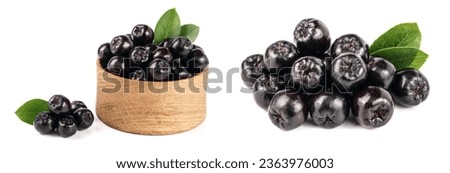 Chokeberry with leaf in wooden bowl isolated on white background. Black aronia berries