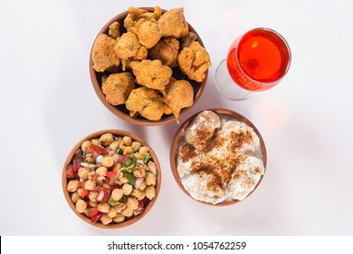 Chola Chana Chaat And Basin Pakora With Dahi Barey, Popular Indian Or Pakistani Street Food, Traditional Ramadan Food, Delicious Ramzan Iftar Meal With Glass Of Red Juice On White Background.