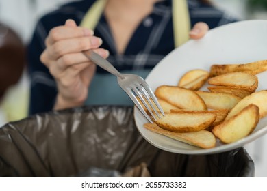 Cholesterol Of Junk Meal Is Fat Meal, Asian Young Household Woman Scraping, Throwing Food Leftovers Into The Garbage, Trash Bin From Potato Chip, Snack In Kitchen. Environmentally Responsible, Ecology