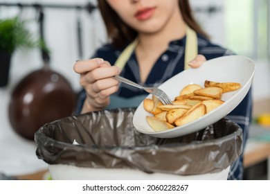 Cholesterol Of Junk Meal Is Fat Meal, Asian Young Household Woman Scraping, Throwing Food Leftovers Into The Garbage, Trash Bin From Potato Chip, Snack In Kitchen. Environmentally Responsible, Ecology