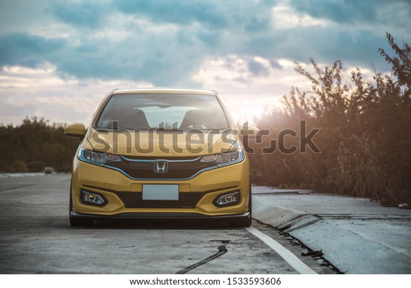 CHONBURI - October\
15: Yellow Car Honda Jazz GK racing car parked on the street. Use\
the Honda logo. Background with car.Honda brand car. October 15,\
2019 in Chonburi,\
Thailand