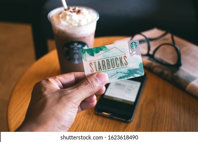 CHONBURI, THAILAND - JANUARY 23, 2020: Starbucks card with a cup of Iced Signature Chocolate in the background. Starbucks is the world's largest coffee house with over 20,000 stores in 61 countries.