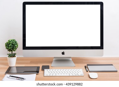 CHONBURI, THAILAND - JUNE 15, 2016: iMac monitor computers and keyboard with iPhone, magic mouse and iPad on wooden desk