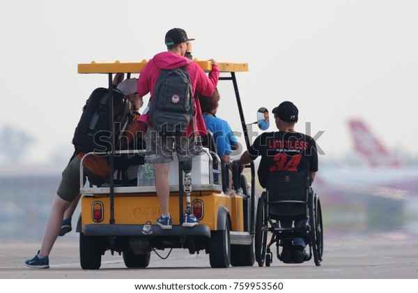 CHONBURI - THAILAND Nov, 17 : Staff coach on the\
wheel chair and drive yellow golf car in The Air Race 1 Thailand\
champion ship on November 17, 2017 at U-Tapao International\
Airport, Chonburi,\
Thailan