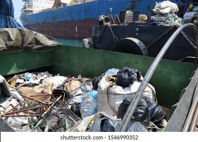 Chonburi, Thailand - OCTOBER 22, 2019: a garbage collection boat from authority collecting trash from barges and commercial ships on the sea.