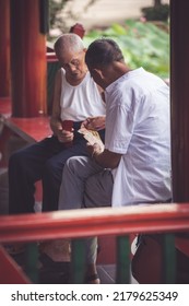 Chongqing, China - August 2019 : Two Senior Chinese Men Playing Cards In Public Park