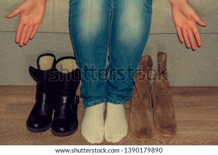 Choose between  shoes. Boots for a modern  woman. Suede and leather shoes. Female hand
