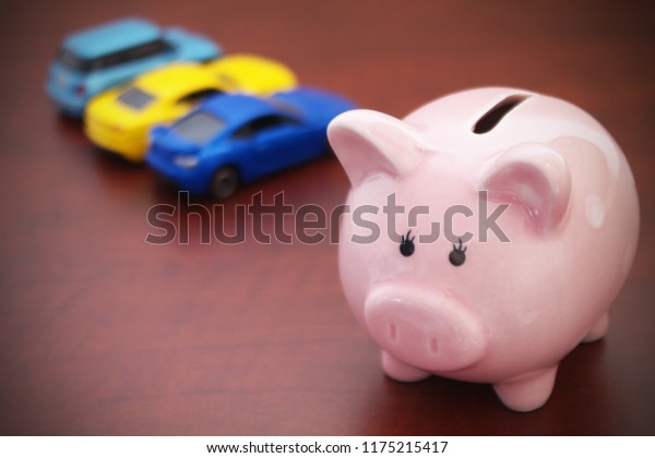 Choose car concept, cars review theme, piggy bank\
with blurred cars