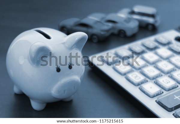 Choose car concept, cars\
review and sell car theme, piggy bank with blurred cars and\
calculator