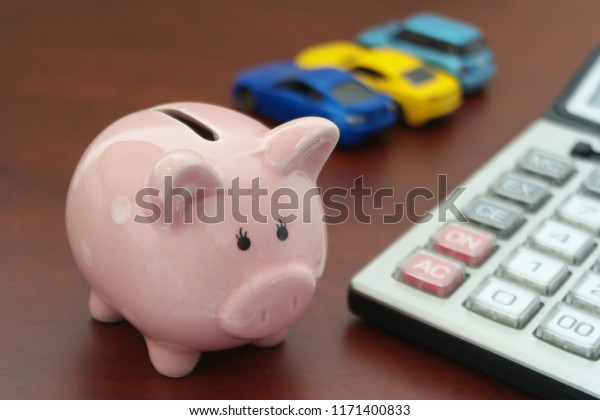 Choose car concept, Sell and buy cars \
theme, piggy bank with blurred cars and\
calculator