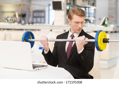 I Choose Healthy Lifestyle. Confident Young Red Hair Man In Formalwear Sitting At The Restaurant And Holding A Dumbbell