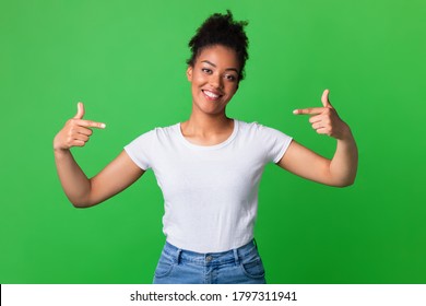 Choose Me. Positive black lady pointing at herself wearing blank white t-shirt, copy space, green studio wall