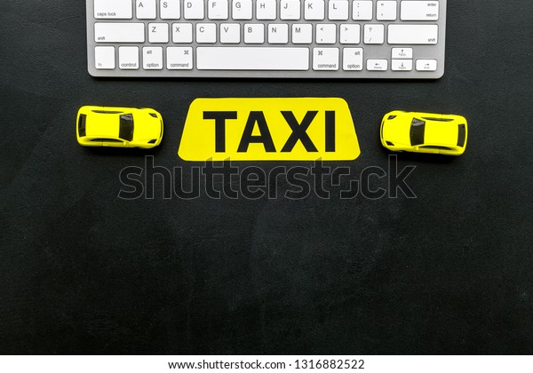 Choose, select taxi concept. Order taxi online. Sign\
ner car toy and keyboard on black background top view space for\
text