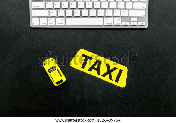 Choose, select taxi concept. Order taxi online. Sign\
ner car toy and keyboard on black background top view space for\
text