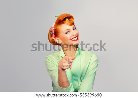 I choose you! Beautiful young businesswoman pinup retro vintage hair style pointing you while standing against white grey background