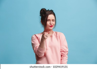 I choose you and order. The smiling business woman point you, want you, half length closeup portrait on blue studio background. The human emotions, facial expression concept. Front view. Trendy colors