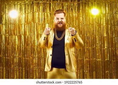 I Choose You. Portrait Of Extravagant Chubby Young Man In Funky Golden Suit, With Gold Chain Around Neck, Standing Against Glittering Background, Pointing At Camera And Inviting You To Join The Party