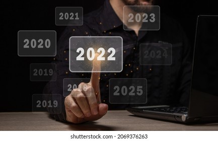 Choosing The New Fiscal Year 2022. The Male Hand Chooses The New 2022 Year. Choosing A New Year And New Business Goals