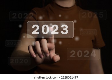 Choosing the new fiscal year 2023. The Woman's hand chooses the new 2023 year. Choosing a new year and new business goals - Shutterstock ID 2228061497