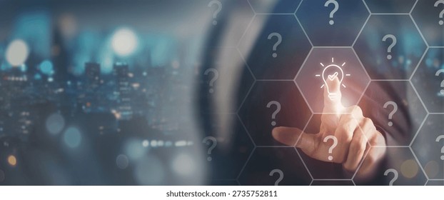 Choosing the right idea or solution concept. Touching a glowing lightbulb icon among question marks, symbolizing idea selection, decision making, innovation and clarity in a complex environment.