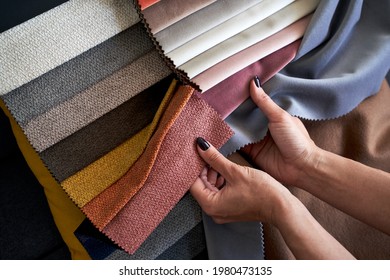 Choosing upholstery fabric color and texture from various colorful samples in a store. Female customer hands touching textile. - Shutterstock ID 1980473135