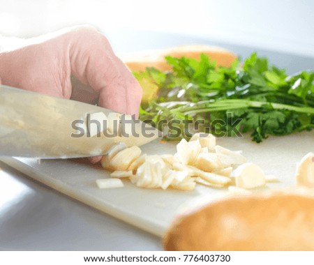 Chop garlic. Parsley. Hands. Cooking at home. Recipe. Knife.